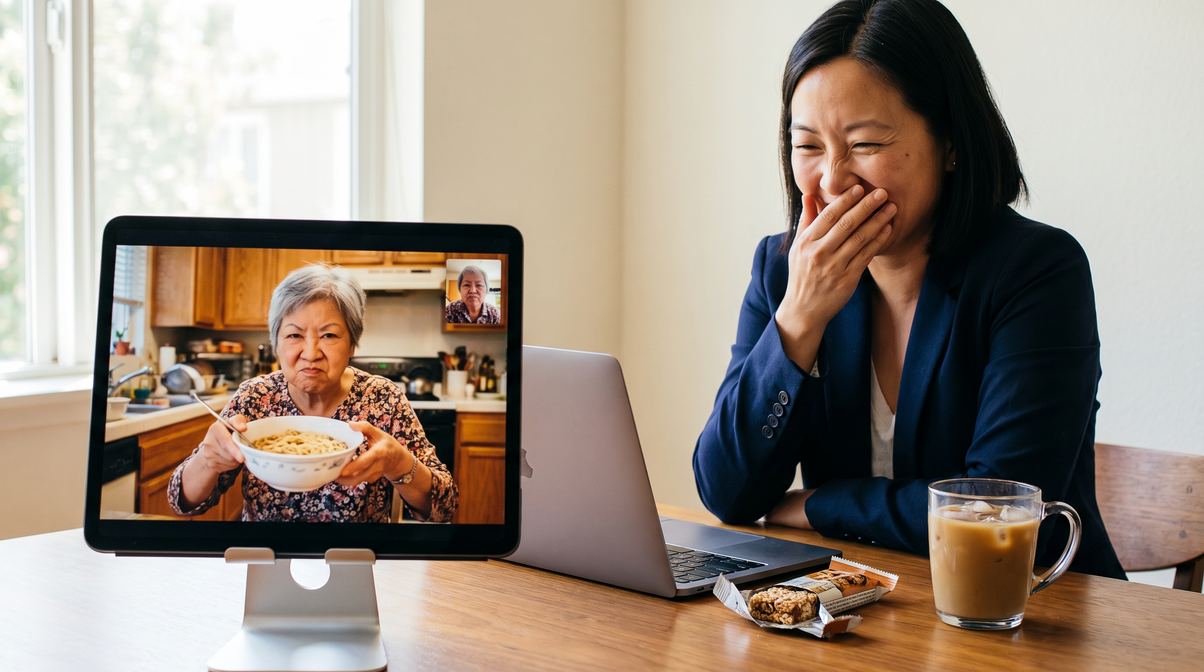 A daughter at her desk laughing as her mother holds up a bowl of noodles on a video call
